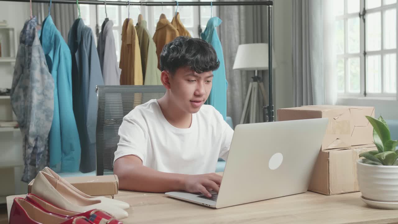 Asian Man Online Seller Typing On Computer While Selling Clothes At Home