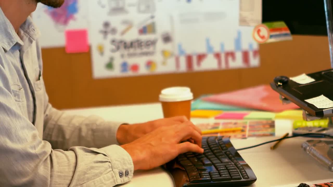 Graphic designer che digita sulla tastiera alla scrivania