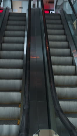 dos escaleras mecánicas, una subiendo y la otra bajando, en un entorno interior moderno. la cámara destaca el diseño elegante y la funcionalidad de las escaleras mecánica en un espacio comercial bien iluminado