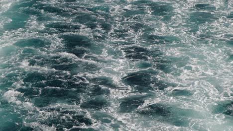 Cinematic-pan-up-of-Waves-from-behind-cruise-ship-out-at-sea