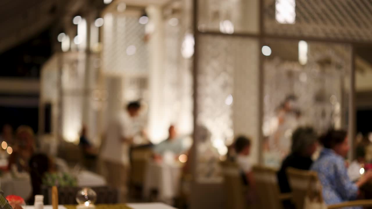 뜨거운, 초대하는 분위기를 조성하는 후원자 식사와 웨이터 서비스와 함께 희미하게 조명 된 레스토랑 장면