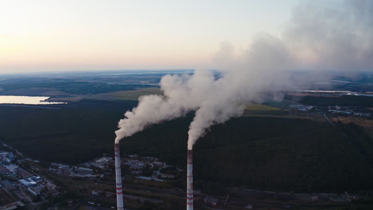 View of pipes with smoke. Power plant with white smoke over blue sky