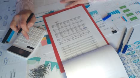 close up de un hombre de negocios manos con pluma trabajando en el escritorio de la oficina y el análisis de gráficos y gráficos en los informes financieros