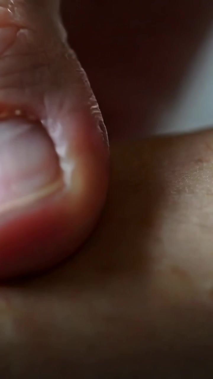 Video verticale: Premendo il polpastrello del pollice si crea una leggera rientranza dopo il contatto sul letto, primo piano che mostra l'unghia.