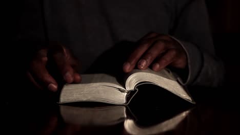 praying to god with hands together with bible and cross caribbean man praying with black background stock video