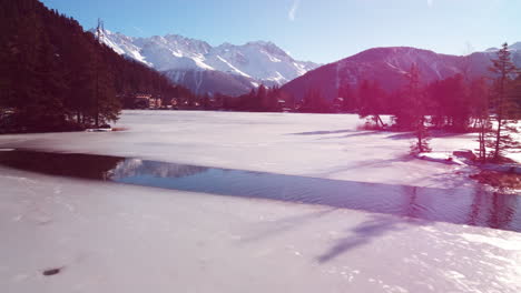 Vuelo-Bajo-Sobre-La-Superficie-De-Un-Lago-Congelado-En-La-Montaña-Suiza