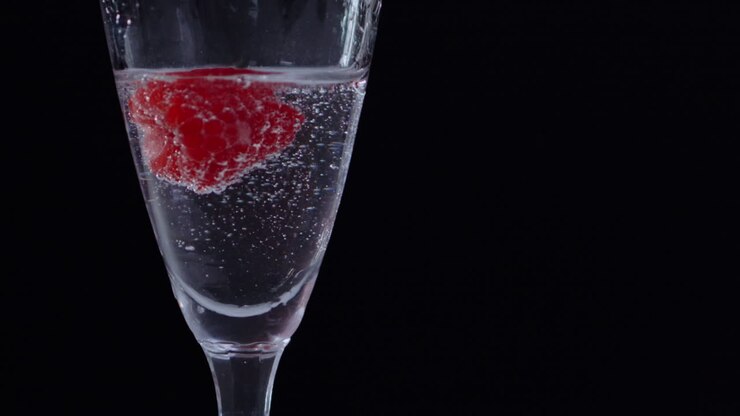 Lampone congelato in un bicchiere d'acqua limpida