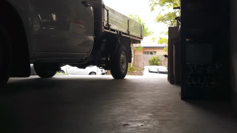 man walking out of garage with pickup truck