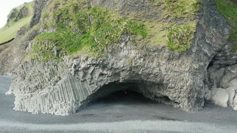 chico de chaqueta roja se encuentra en la famosa cueva hálsanefshellir en islandia