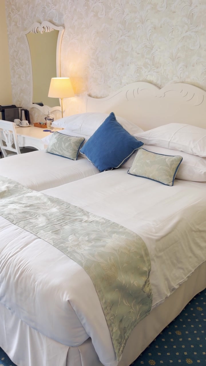 POV dalla fotocamera del telefono in una lussuosa camera d'albergo o suite con letti gemelli, scrivania e lampade. Godendosi un resort turistico o un viaggio d'affari. Contenuto generato dall'utente (UGC) di un vlogger di viaggi in un reel video sociale verticale.