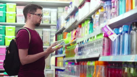 hombre comprando botellas de agua en una tienda