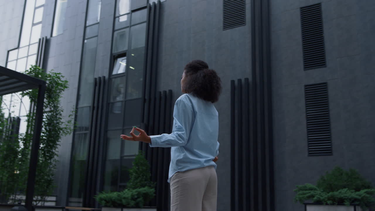 gerente estresado meditando en un edificio de oficinas al aire libre.