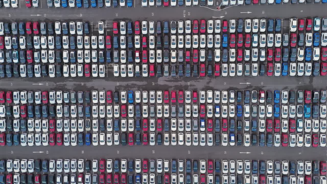 Abstract aerial composition featuring systematic arrangement of vehicles creating visual data patterns, emphasizing geometric organization and scale of automotive logistics