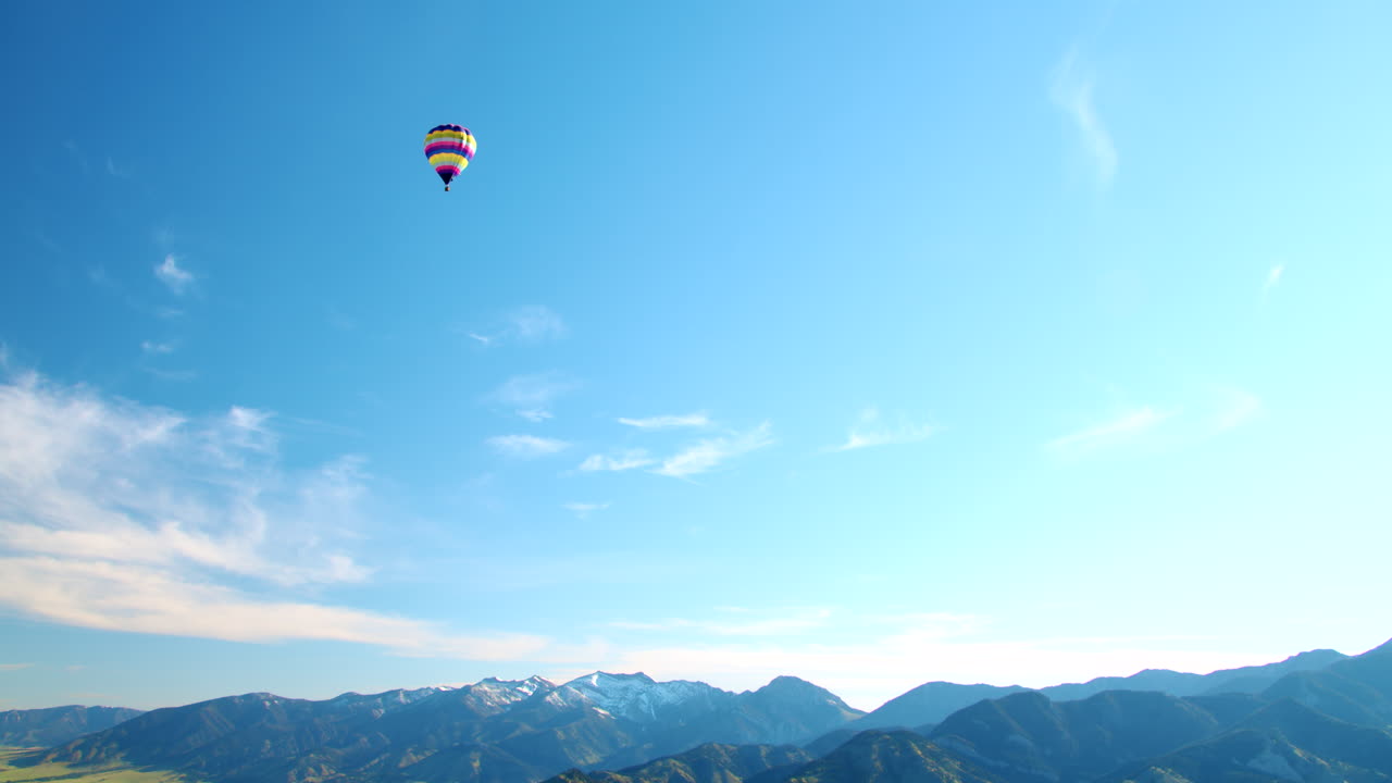 해가 뜨는 시점에서 산을 내려다보는 지평선 위를 날아다니는 열기구 - 넓은 공중 전망