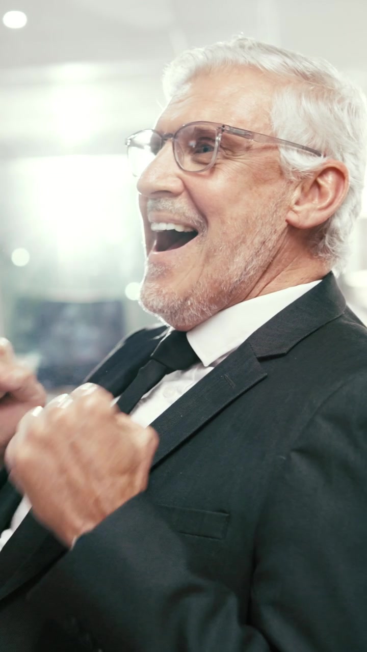 Imprenditore anziano di successo che festeggia in ufficio
