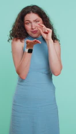 mujer mostrando un pequeño gesto con una sonrisa escéptica mostrando un signo mínimo midiendo un tamaño pequeño