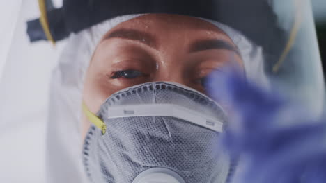 tired doctor taking off respirator and face shield closeup female medical practitioner with sweaty face taking off mask and face shield looking at camera in coronavirus clinic