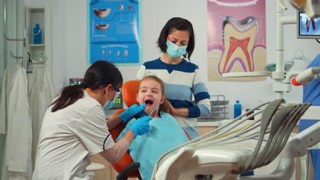 Stomatologist-doctor-checking-tooth-health-of-young-patient