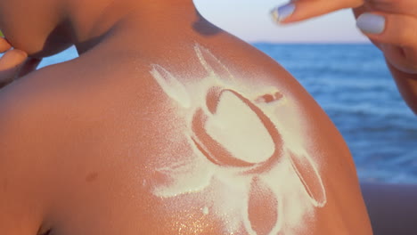 hacer sol con crema protector solar en la espalda de los niños