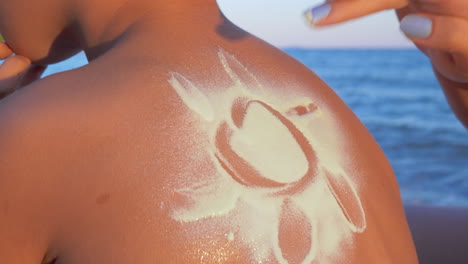 making sun with sunscreen cream on childs back