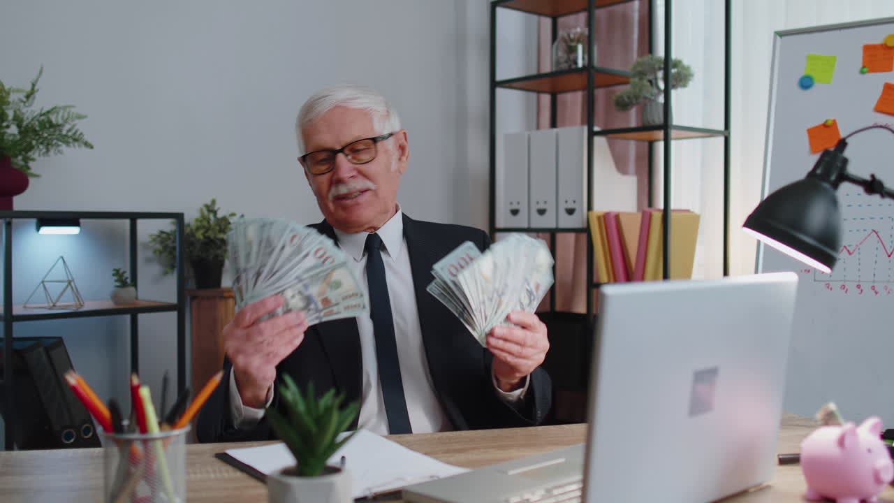 Business man accountant celebrating business success dancing with stack of money dollar cash