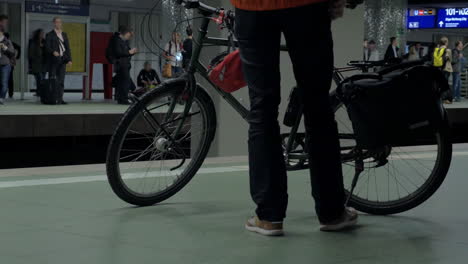 hombre con bicicleta esperando el tren del metro