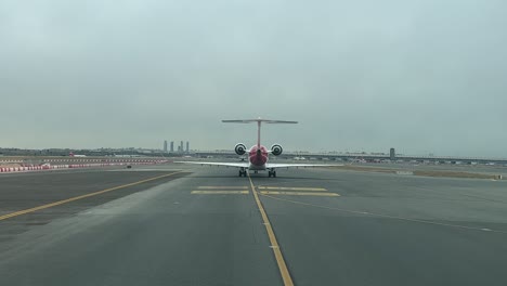 el punto de vista de un piloto: vista trasera de un jet de tamaño mediano que pasa por una calle de rodaje hasta la pista para despegar