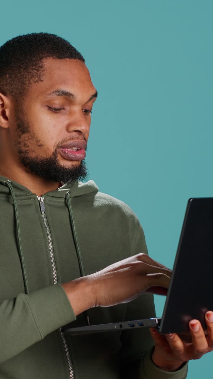 Young Man Using Laptop and Credit Card for Online Shopping