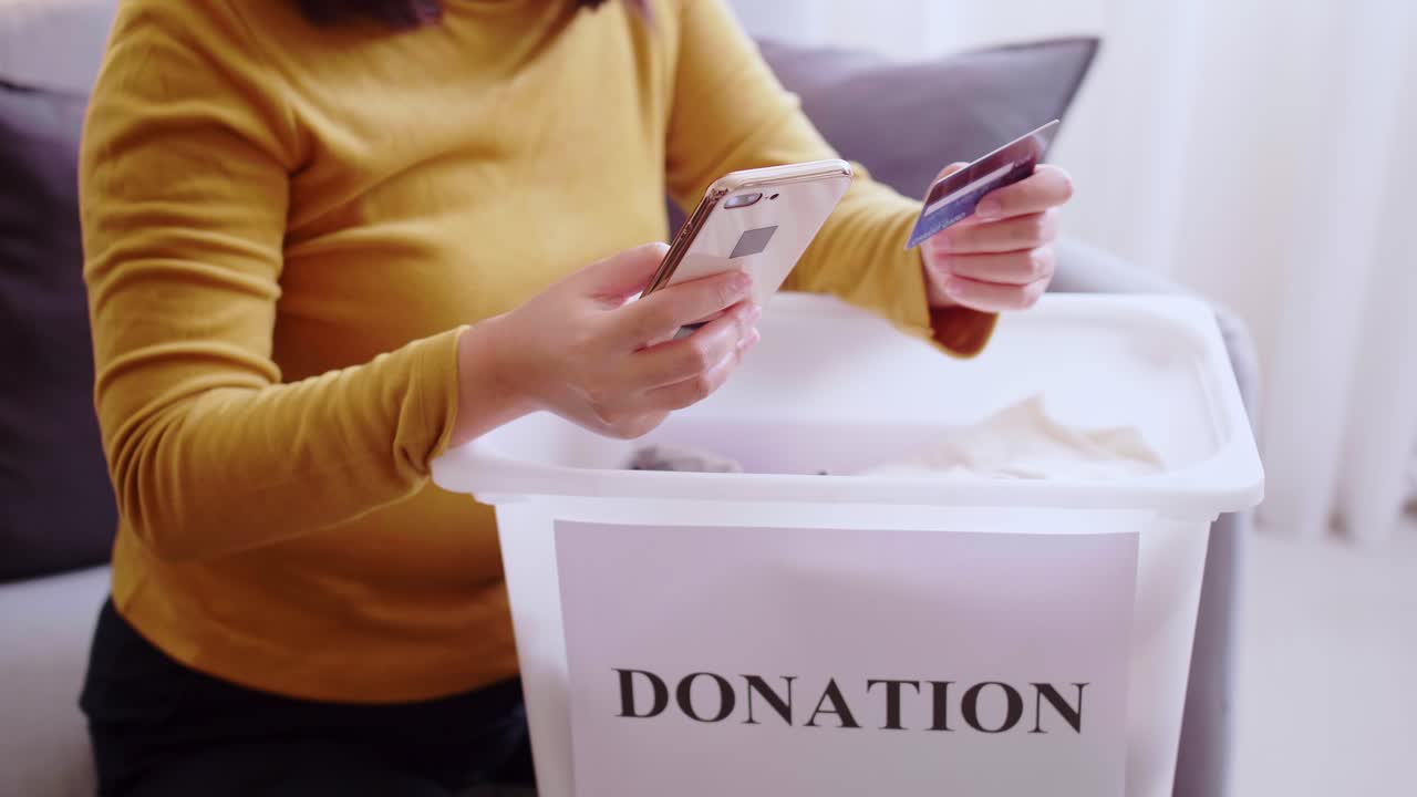 detalle de manos femeninas haciendo una donación con tarjeta de crédito