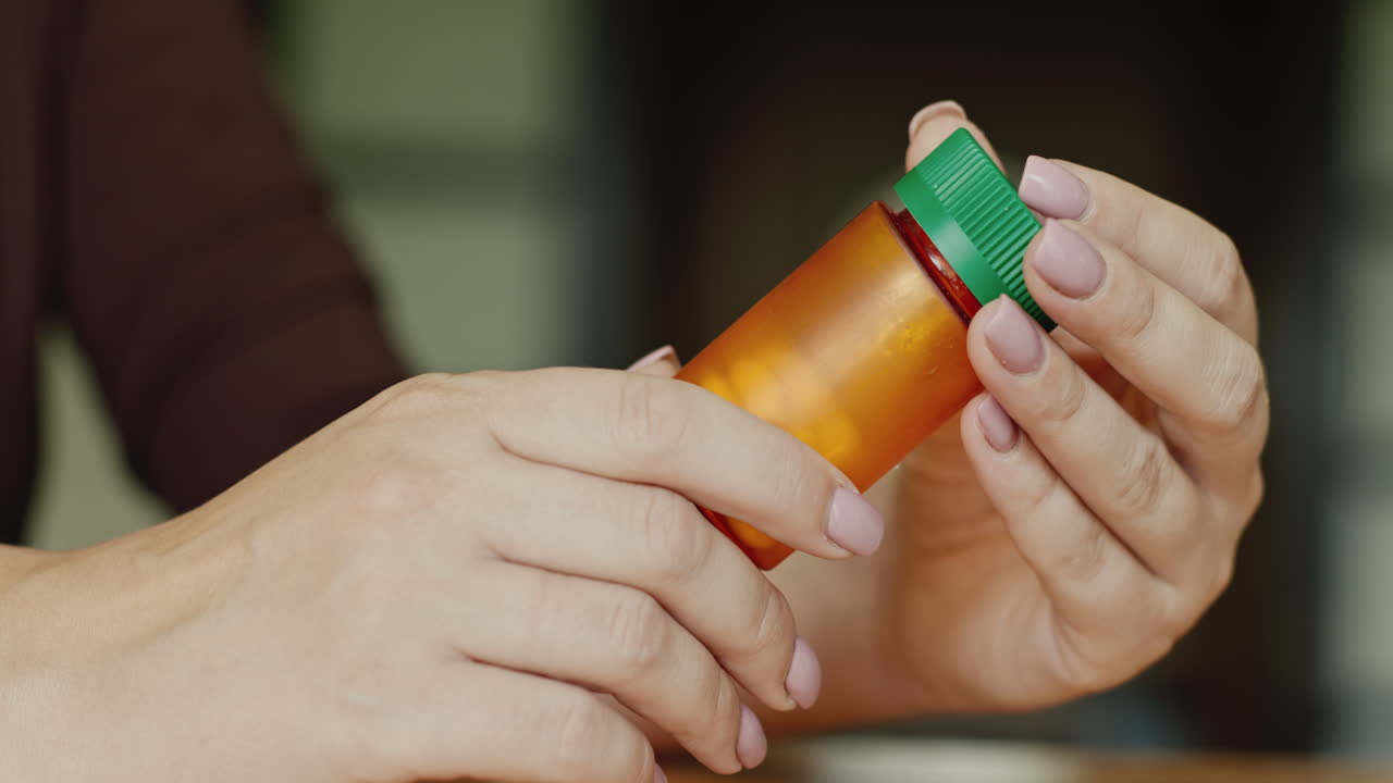 여자가 약병을 들고 있다