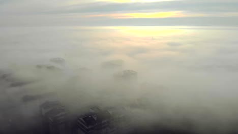 heavy fog over the city. the camera moves uphill and opens a panorama of the fog that lies over the city.