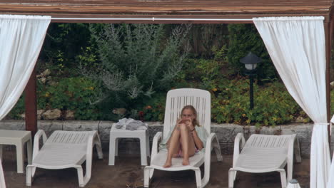beautiful young women relaxing on the deck chair near the pool