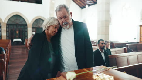 funeral, coffin and senior couple hug for goodbye