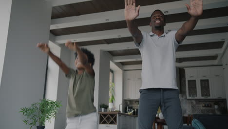 father and son dancing at home
