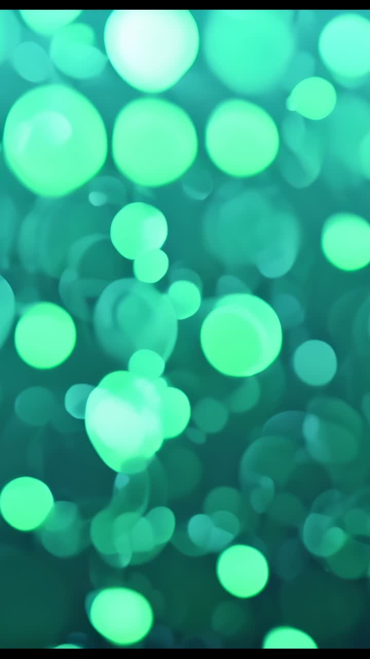 Vertical video: Pulsing blurred green light spots drifting in abstract scene, ambient bokeh