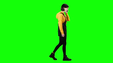 teenage girl walking and talking on phone - green screen