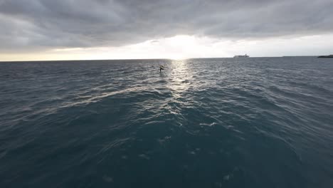 overcast sky above a rocky breakwater in genoa, italy, waves crashing, wide-angle, fpv drone shot