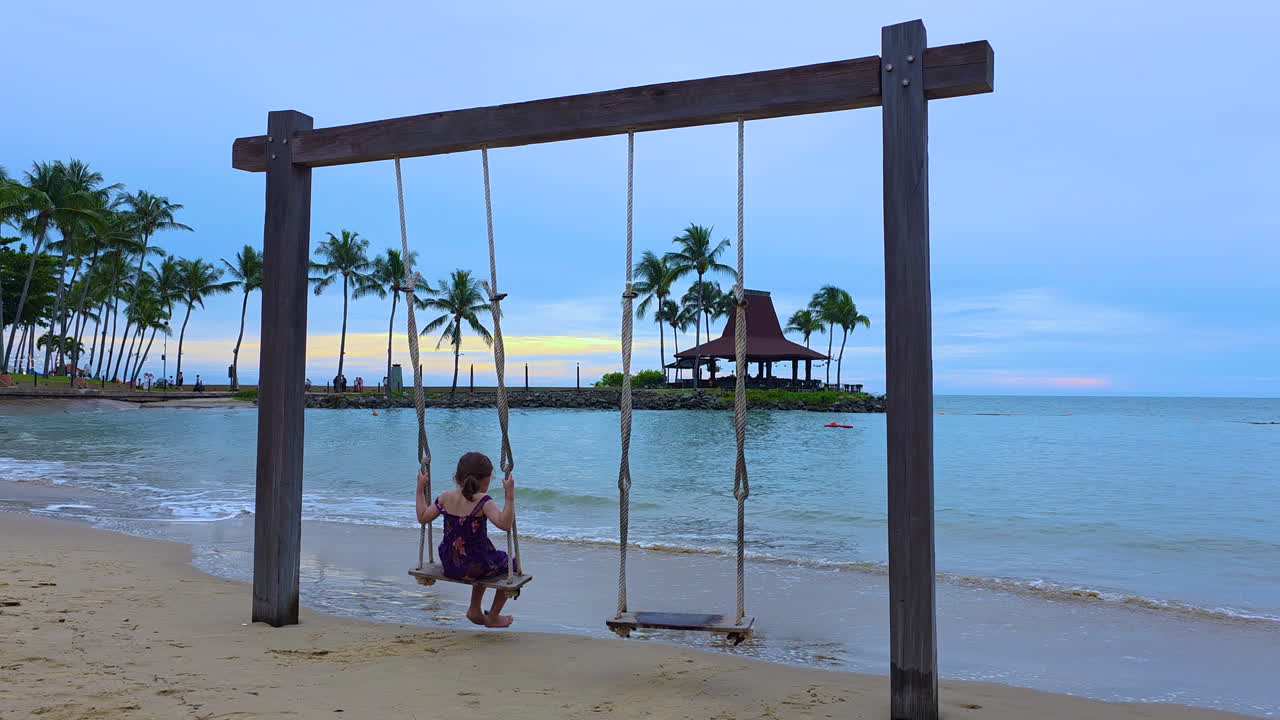 Happy Young Girl Swinging On The Sandy Seacoast Of Kota Kinabalu In Sabah, Malaysia. Static Shot