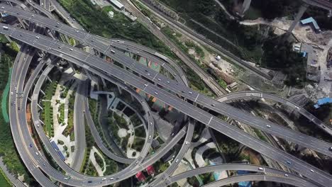 aerial shot of circular roads and highways floating five levels exchange in chongqing and cars driving on them, huangjuewan exchange