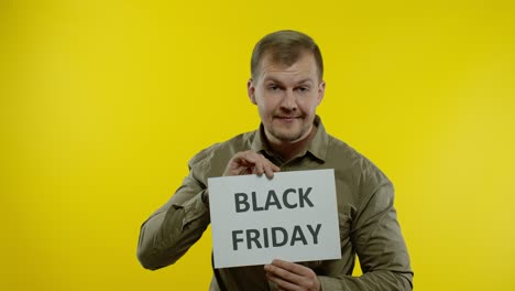Joyful-man-showing-Black-Friday-inscription-note,-smiling-looking-satisfied-with-low-prices