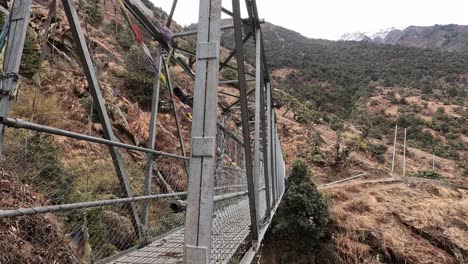 acercándose a un puente de senderismo metálico pasando por un valle en la caminata del valle de langtang