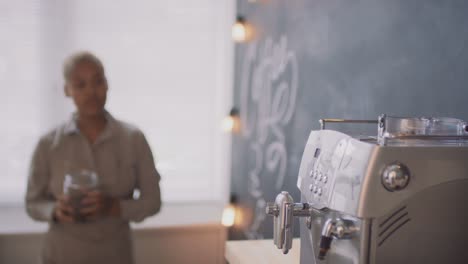 afro muslim waitress pours coffee into coffee machine