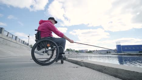 person with a physical disability who uses wheelchair fishing from fishing pier