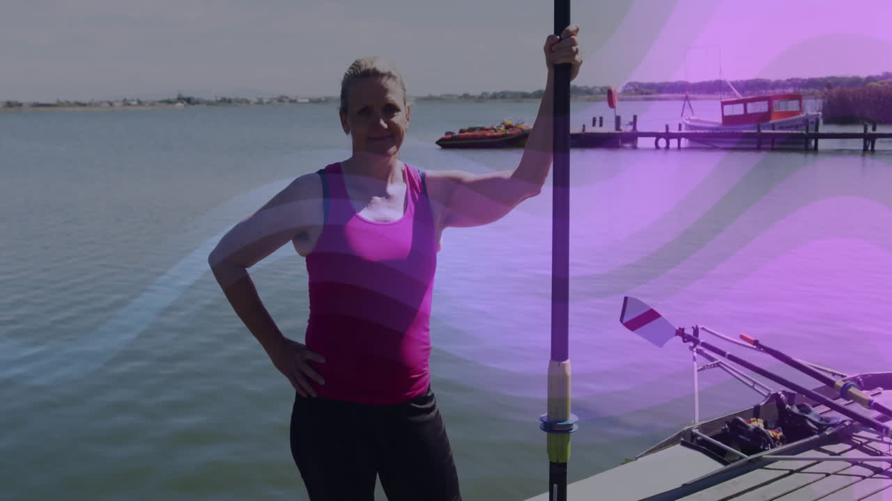 woman standing at lakeside holding paddle by docked boat, with animated health charts floating