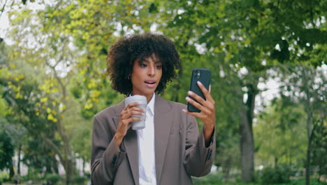 confident woman talking camera walking park with coffee close up. girl speaking
