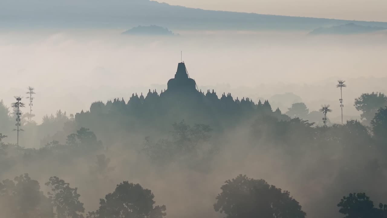 Vista aerea del Tempio di Borobudur circondato dalla nebbia mattutina, paesaggio tranquillo e sito del patrimonio culturale in Indonesia