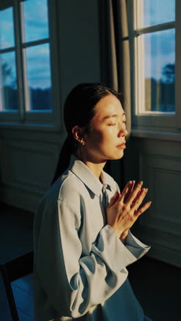 woman meditating by the window