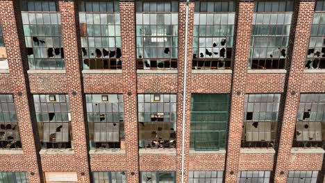 old, abandoned brick building with shattered glass windows