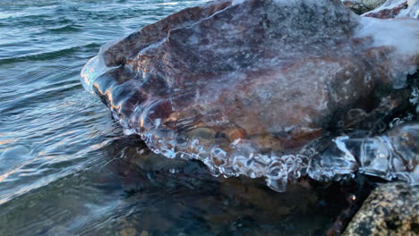 Close-up-of-ice-covered-rock-on-bank-of-Spokane-River-during-winter