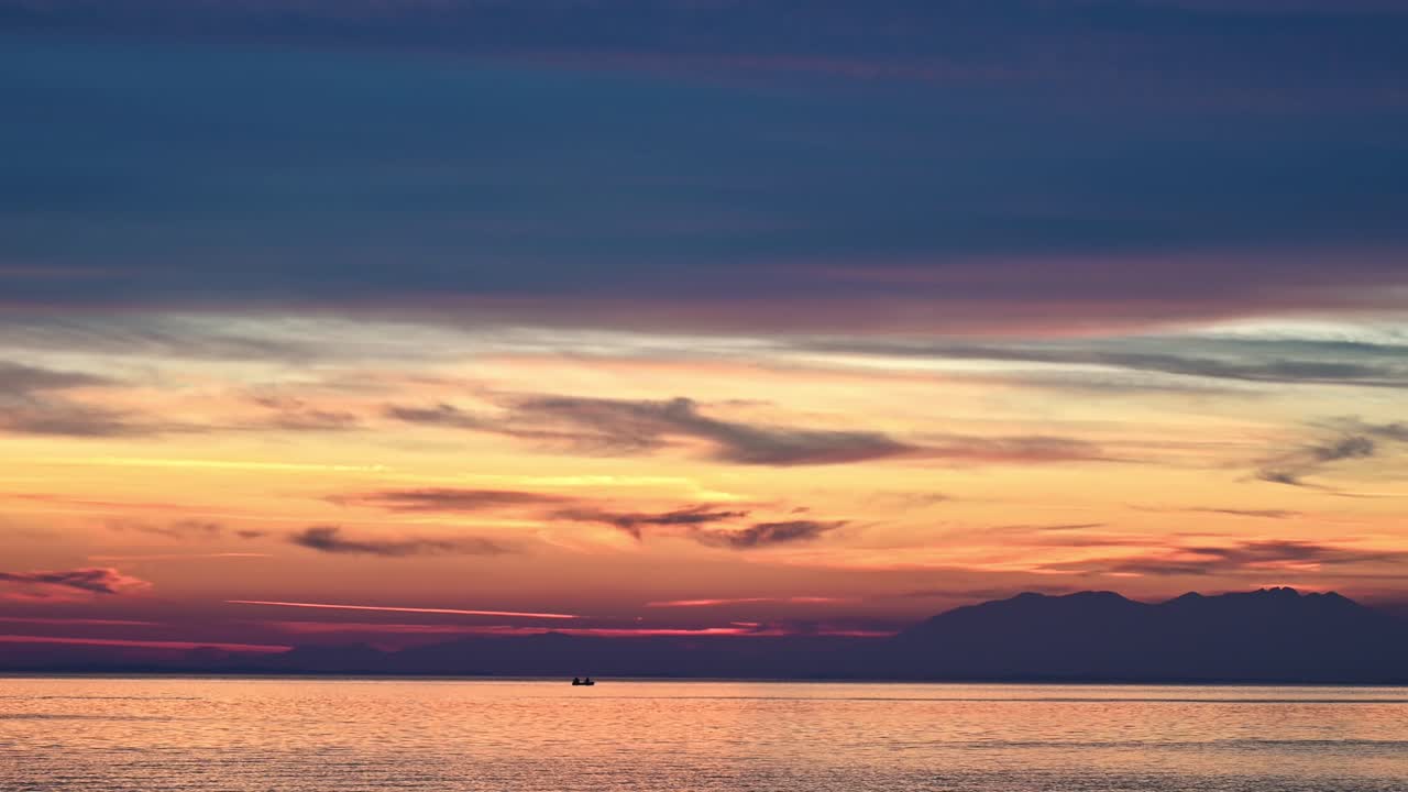 エーゲ海の夕日。黄色い光、遠くの陸地、水、ギリシャ。